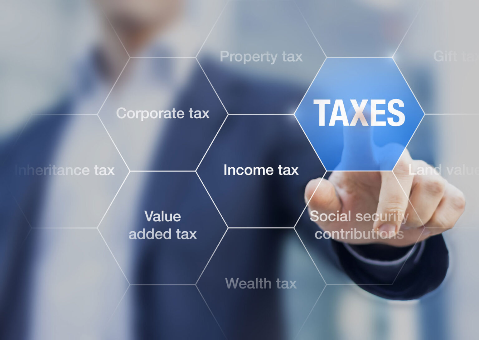 A person pointing to the word taxes on an interactive screen.