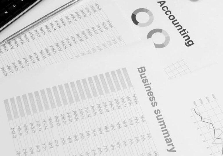 Financial documents laid out with laptop and calculator